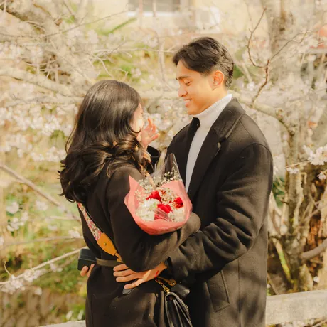 Eden holding a bouquet of red flowers with Priam